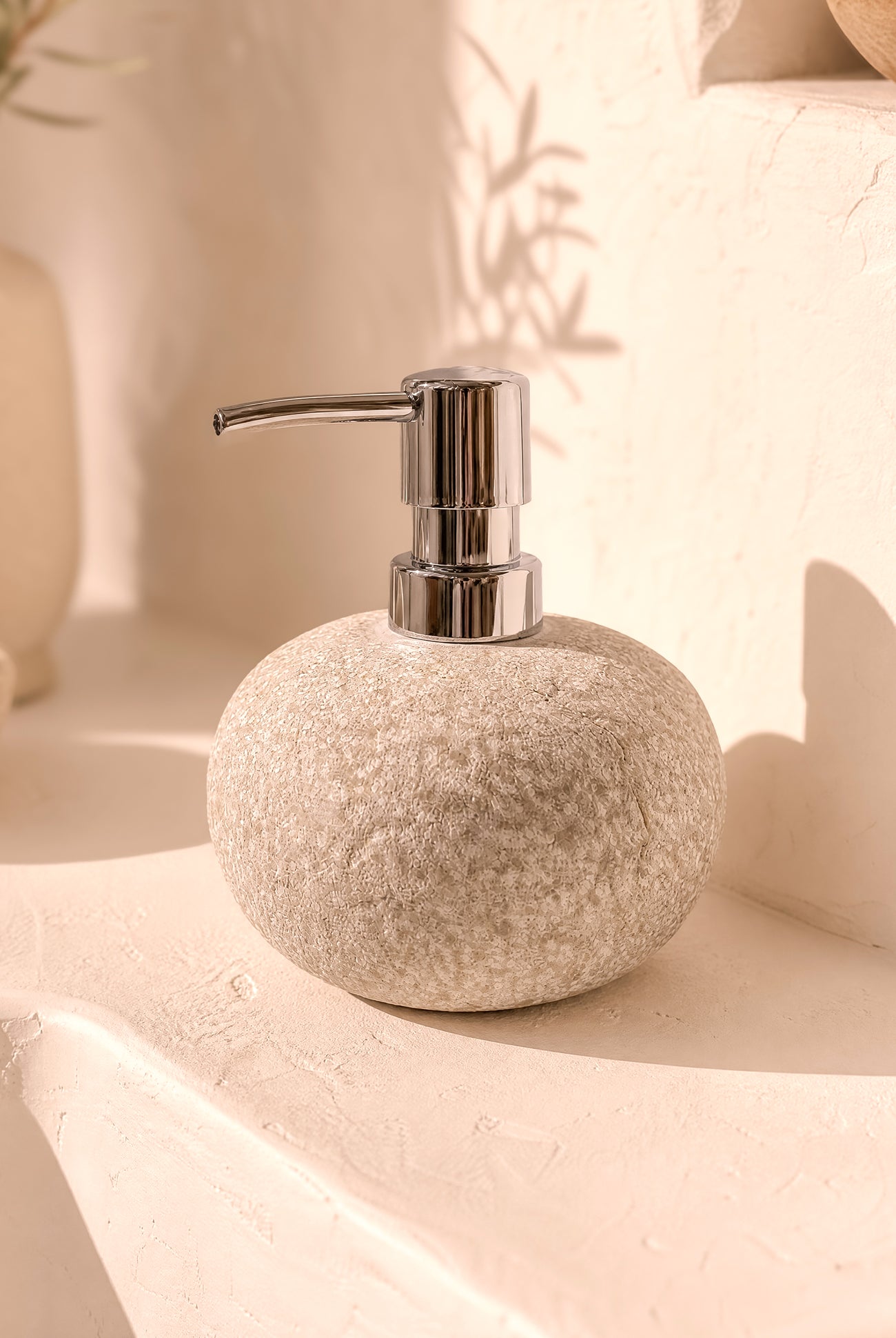 Ibizamode natural stone soap dispenser with textured finish in bohemian bathroom interior