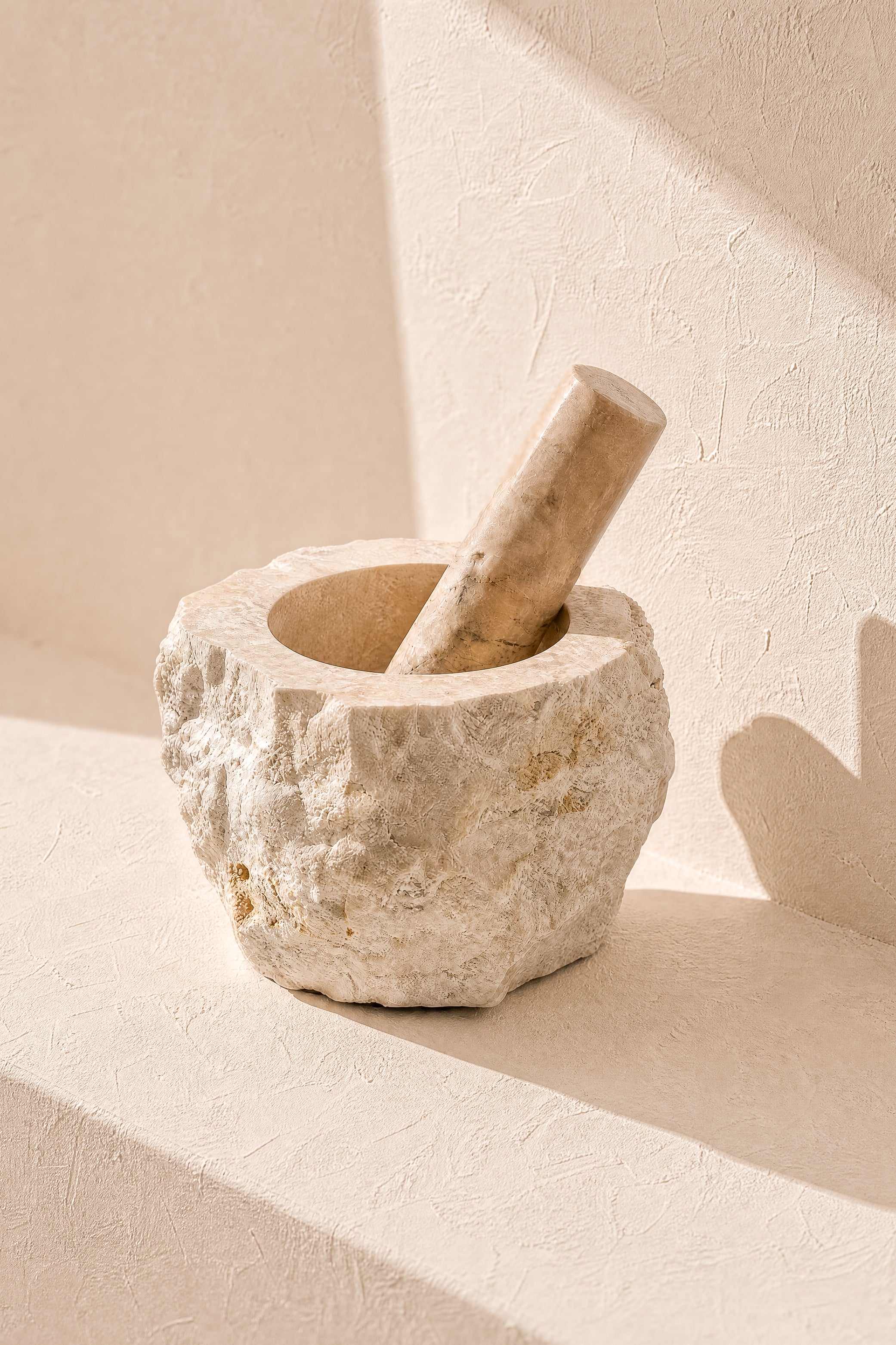 Ibizamode natural marble mortar and pestle with organic stone texture in bohemian interior